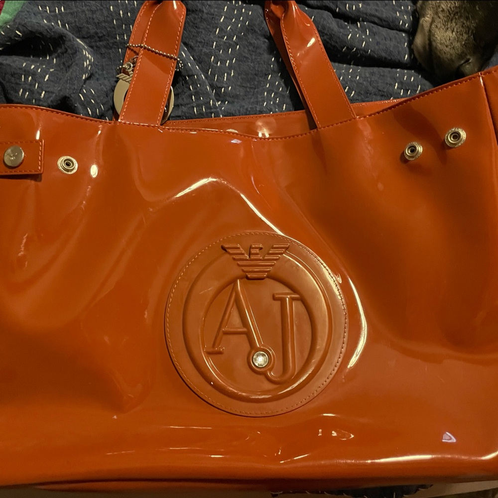 Unused new WO tags. Armani Jeans orange patent bag, excellent condition.